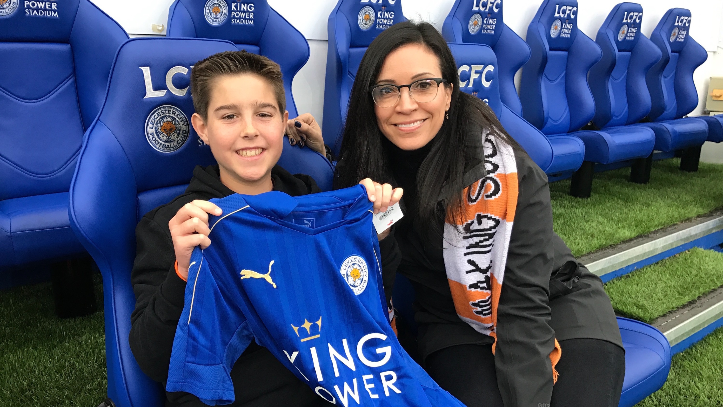 Travis proudly holds his LCFC mascot jersey next to CWFund board member Johanna Agueda