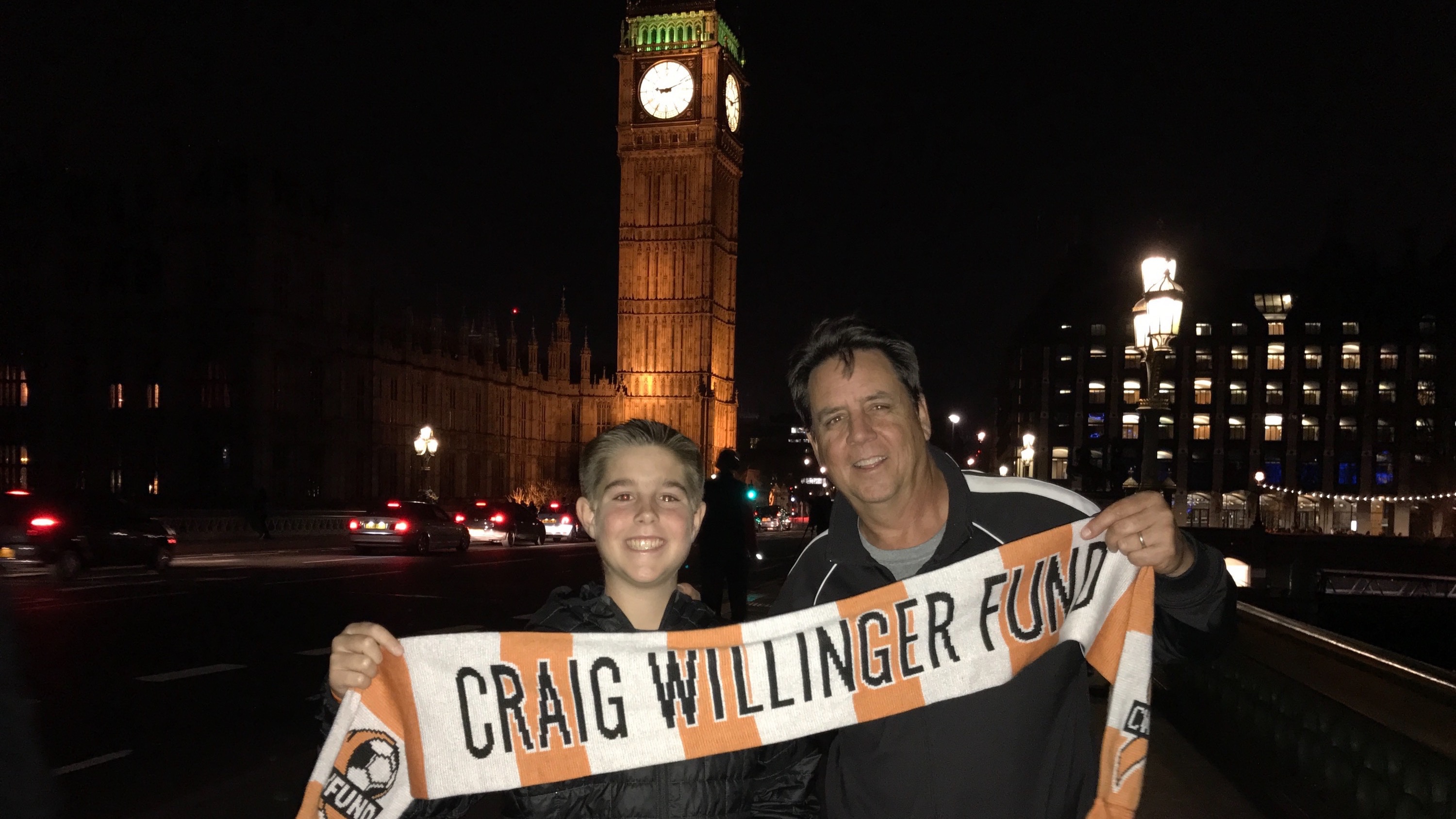 Travis and Tim Hackett hoist a Craig Willinger Fund scarf in front of Big Ben